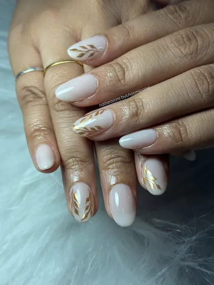 The contrast between the soft nude and the metallic gold is what makes this design so effective.