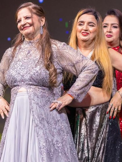 The ladies of the family, from the dadi to the younger generation, striking a pose together on stage. A beautiful picture of grace, confidence, and family bonds.