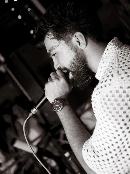 "Music, once admitted to the soul, becomes a sort of life spirit, and never dies." A black and white close-up of me on the mic.