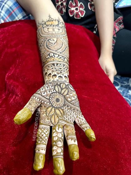 A single hand from a bridal set, featuring a sunflower mandala on the palm.