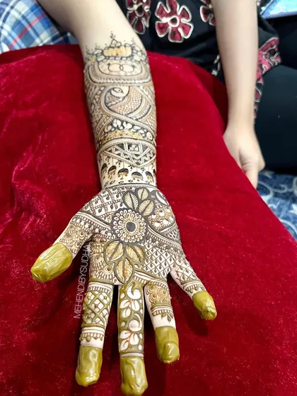A single hand from a bridal set, featuring a sunflower mandala on the palm.