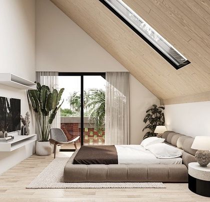 The master suite in the Kolgaon Masterplan is housed on the top level under a sloping wooden roof with a skylight. The room opens onto a private balcony, creating a light-filled, expansive, and attic-like personal space.