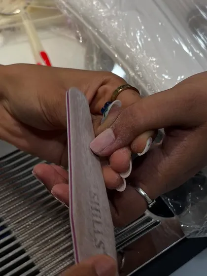 The process in action. Here I am carefully filing and shaping a client's nails to create the perfect canvas for our nail art.