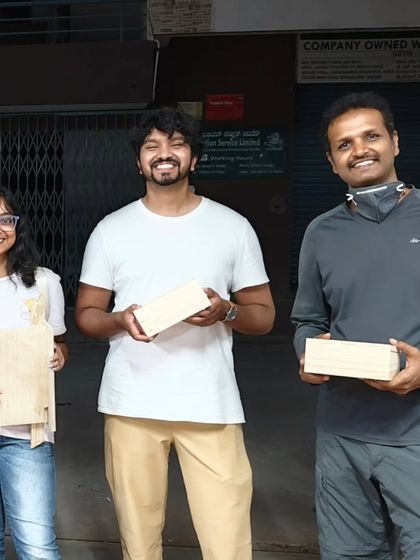 Proudly showing off their handmade projects. This group created a serving board and a pair of sturdy wooden boxes, learning essential skills along the way.