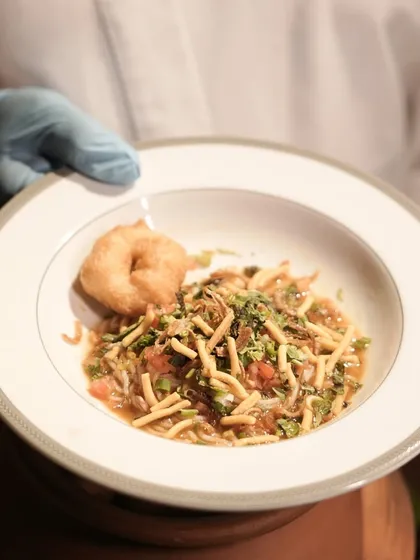 Showcasing our culinary innovation, this is our Rassam Khow Suey. We've fused the tangy, spicy flavours of South Indian Rassam with the comforting format of Burmese Khow Suey for a truly unique fusion dish.