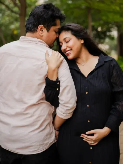 A warm and affectionate maternity pose. The mom-to-be rests her head on her partner's shoulder, creating a feeling of comfort and security.