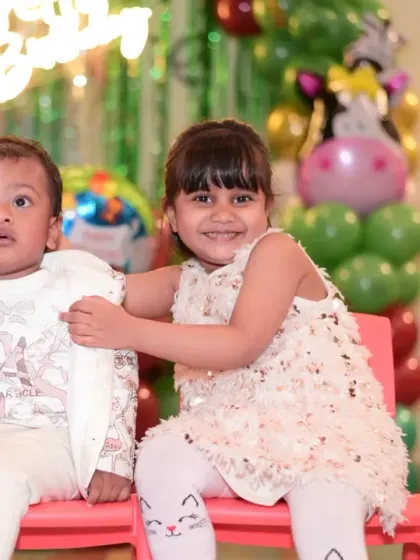 Siblings posing together at a birthday party. It's a joy to see them celebrating together.