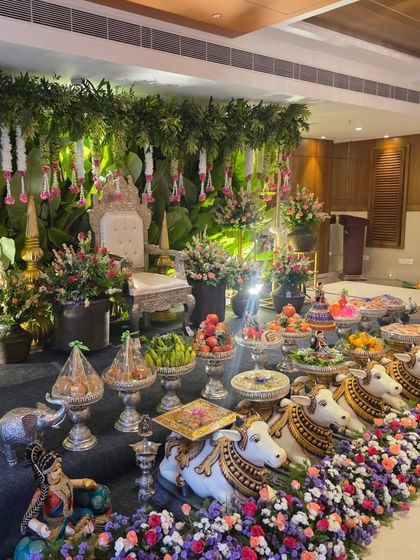 An elegant stage with a wall of lush greenery and hanging floral garlands.