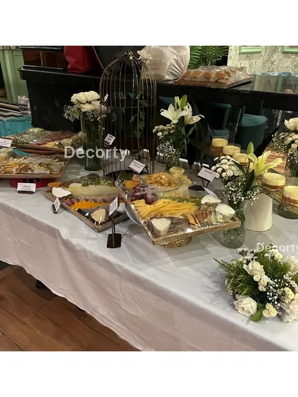 I also manage event catering and presentation. For the Vespa event, I set up this beautiful grazing table with a variety of cheese platters and appetizers, decorated with fresh flowers to match the event's decor.