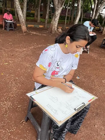 A student works on her human figure sketches during our outdoor session. The goal is to quickly capture the posture and movement of people in the park.