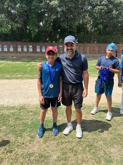 A player proudly wearing his medal next to his coach. We recognize and reward hard work and achievement.