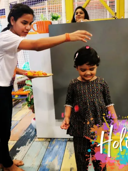 A smile of anticipation during our Holi celebration. We use flower petals and organic colors for a child-friendly experience.