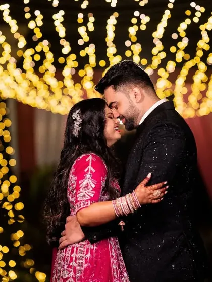 Using dramatic lighting to create a magical moment. This sangeet portrait uses the background bokeh to frame the couple, turning a simple night shot into something truly cinematic and romantic. This is how we make your event photography stand out.