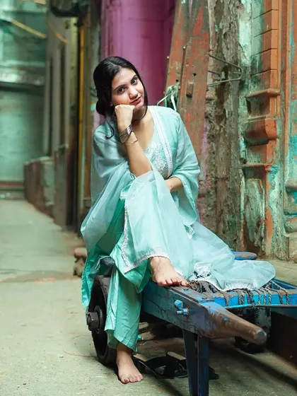 A quiet moment in the middle of a bustling city alley. This portrait combines traditional ethnic wear with a raw, street-style setting, creating a beautiful contrast that feels both authentic and artistic. It's a perfect example of a personal portrait session.