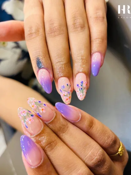 We combined two trends in one with this beautiful set. It features a soft lavender-to-nude ombre base on almond-shaped extensions, with delicate, hand-painted floral art on select nails for a touch of whimsical elegance.