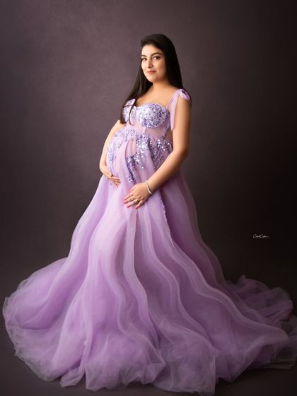 This gorgeous mama glows in a lavender tulle gown with intricate silver embroidery on the bodice, holding her bump with such tenderness.