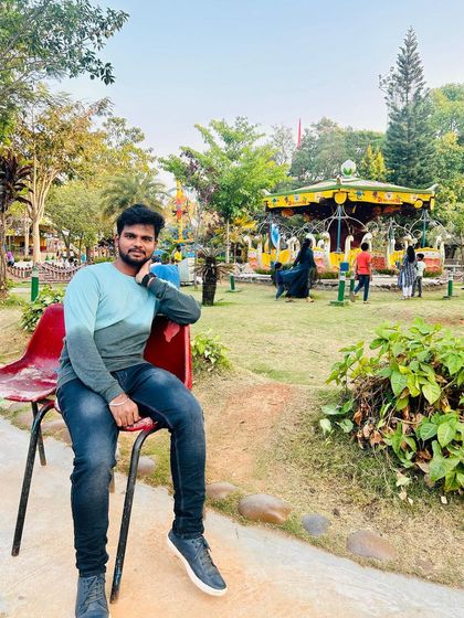 Relaxing in the park area of Fun World, with a carousel in the background.