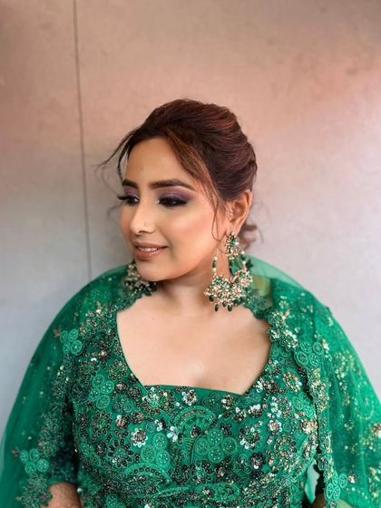 A side profile showcasing the soft purple smokey eye and the elegant updo created for this Sangeet look.