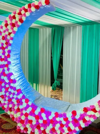 A close-up of the large, illuminated floral moon prop, a popular and beautiful seating choice for the mom-to-be at a baby shower.
