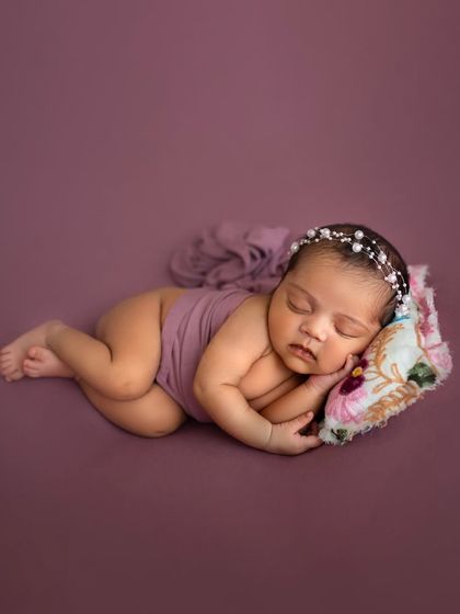 Sometimes, the most powerful portraits are the simplest. I will teach you classic posing techniques, like this side-lying pose on a simple backdrop, that focus all the attention on the baby's peaceful features.