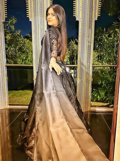 The back view of the black gown, showing the sheer back and the beautiful flow of the skirt.