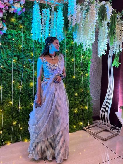 This beautiful ready-to-wear saree features a subtle striped pattern and a heavily embellished blouse. It’s a unique and stylish rental choice for a wedding guest who wants to stand out.