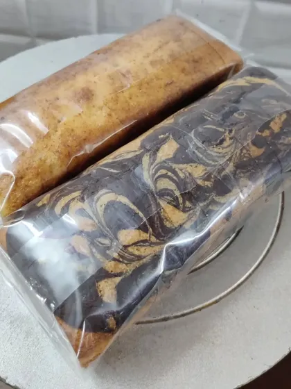 This image shows two of my popular loaf cake varieties, individually wrapped. On the right is a beautiful Marble Cake with swirls of vanilla and chocolate, next to a classic Mawa cake.