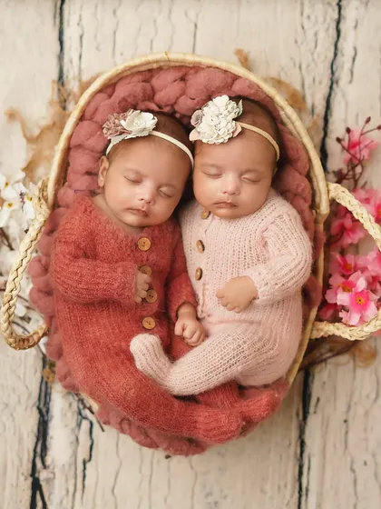 An overhead shot of the twins nestled together in a basket. Posing twins requires extra care to ensure they are both comfortable and beautifully composed.