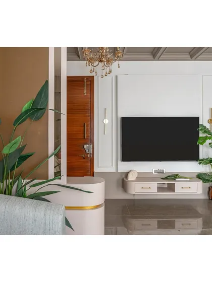 The television unit is designed to be both functional and discreet, with clean lines and integrated storage. We flanked it with lush greenery to bring a touch of nature indoors and soften the technological elements.