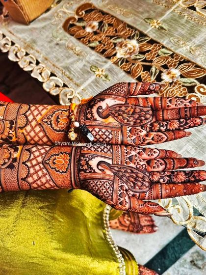 A shot focusing on the palms of the previous design, which feature elaborate peacock motifs.