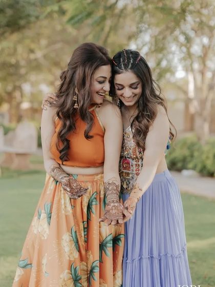 A happy, candid shot of the sisters. Their matching wavy hairstyles look beautiful.