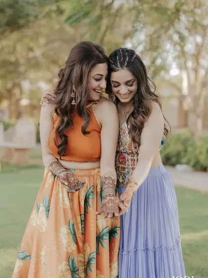 A happy, candid shot of the sisters. Their matching wavy hairstyles look beautiful.
