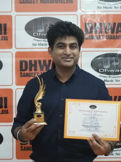 An adult student proudly holds his certificate and award for his artistic skills.