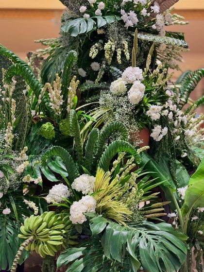 A close-up on the intricate layers of green foliage, from curled fern fronds to broad monstera leaves.