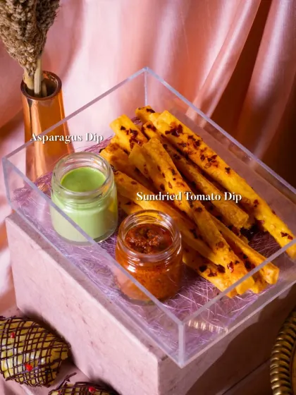 The cheese straws are paired with two of my signature dips: a creamy Asparagus Dip and a tangy Sundried Tomato Dip, presented in a clear acrylic tray.
