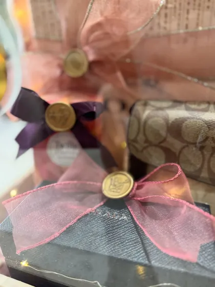 The beauty is in the details. This close-up shows the delicate organza ribbons and custom wax seals on individual gifts within the trousseau box.