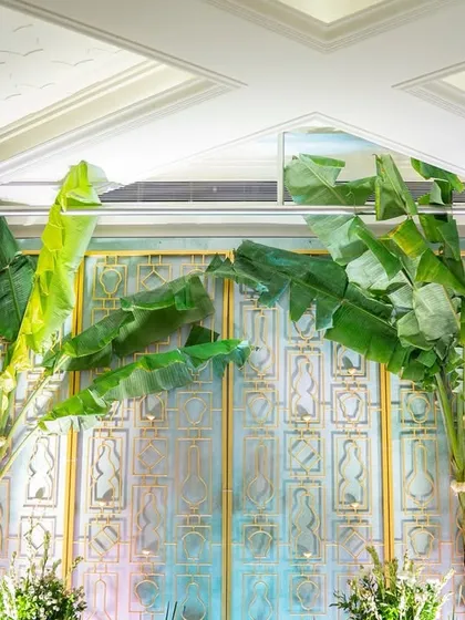 A detail of the 'Kel Baradari' wedding mandap, showing the lush banana trees against a custom-designed backdrop. This setup was a tribute to South Indian wedding traditions, emphasizing natural beauty and sacred symbolism.