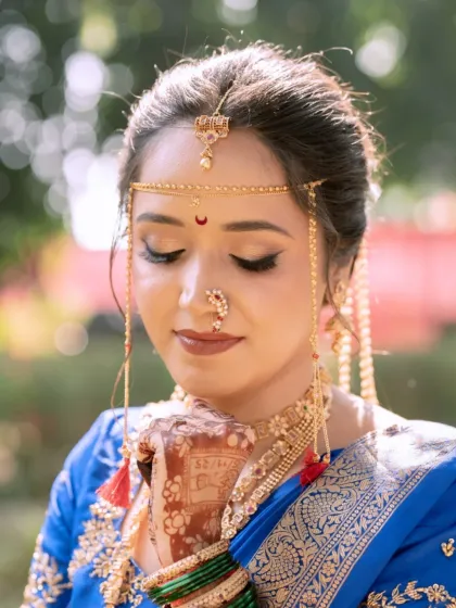 A closer look at the eye makeup, featuring a soft blend of neutral tones and a sharp wing to define the eyes. The traditional nath and bindi complete this classic Maharashtrian bridal style.