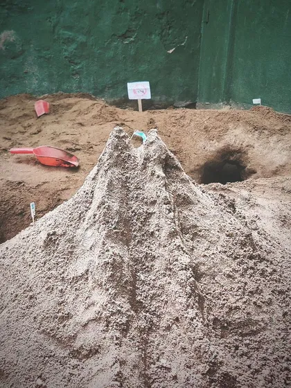 A magnificent volcano rises from the sandpit, complete with tunnels and caves. The children's constructions are often elaborate and detailed, reflecting their rich inner worlds.