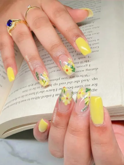 A final, clear shot of the yellow daisy nail art. The combination of solid color and detailed floral work is perfectly balanced.