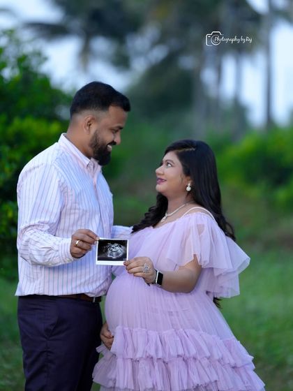 A loving couple's portrait showing them holding their baby's ultrasound scan. This is a wonderful way to include your little one in the photoshoot.