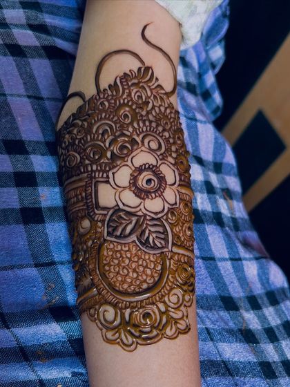 A close-up of the armband for Bride Rumana. The design features a large, beautiful flower as the centerpiece.