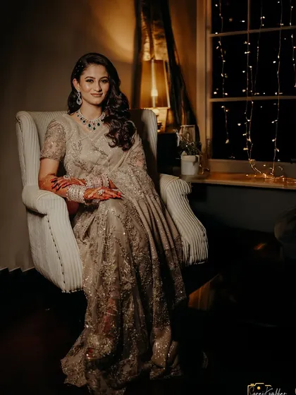 A full-length portrait of the bride, looking poised and elegant in her reception attire.