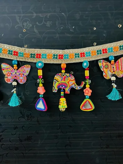 The 'Bageecha Toran' is like a garden for your door, made with wooden birds, elephants, and butterflies featuring my art prints. This piece is completely plastic-free and full of heartwork.