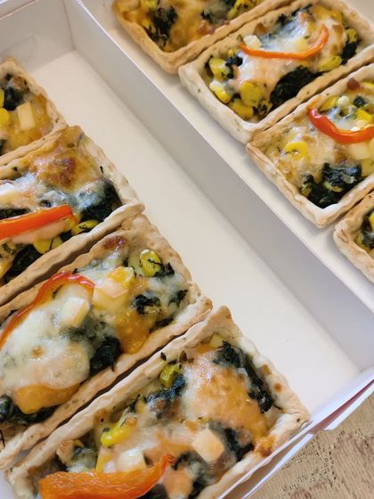 Our mini Corn Spinach Quiches, packed and ready for delivery. These individual portions are perfect for parties and events, offering a delicious, cheesy, and savoury bite.