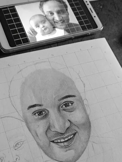 This image shows my process: the reference photo is on my phone, and the gridded sketch is underway on the paper below. It's how I ensure accuracy in my family portraits.