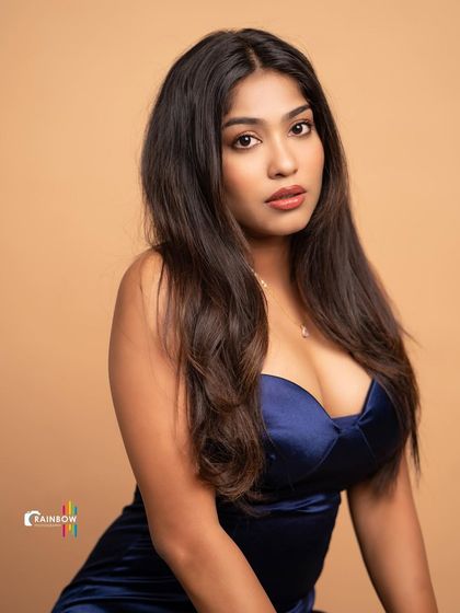 A glamorous shot in a satin blue dress. The studio lighting highlights the sheen of the fabric and sculpts the model's features beautifully.