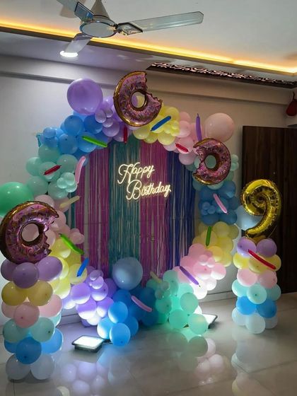 A colorful "Donut Grow Up" candy-themed party for a 9th birthday, featuring a ring arch with donut foil balloons.