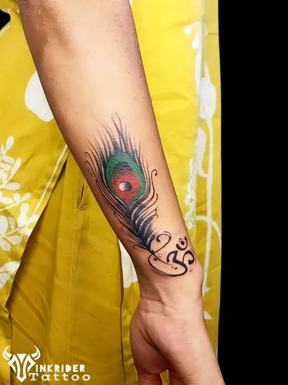 This vibrant peacock feather and Om symbol was designed to cover and correct a previous tattoo. The bright colors and bold lines create a beautiful new focus point.
