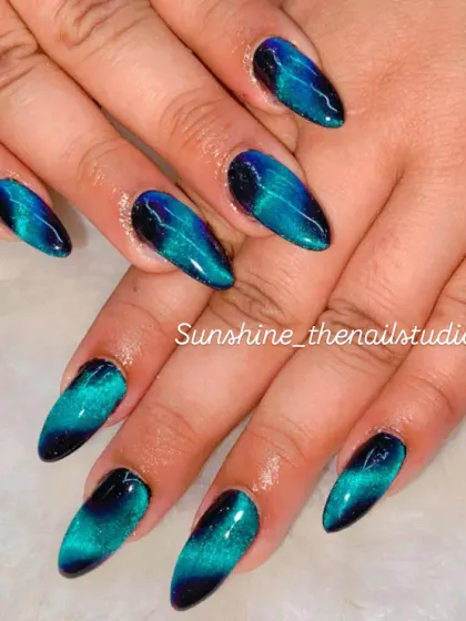 The magic of cat eye polish is something else. Here, I've created a deep, mesmerizing look with a blue and black cat eye effect on sharp almond-shaped extensions.